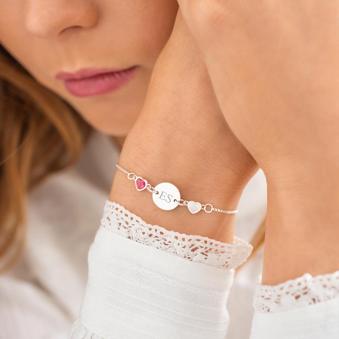 silver plated disc bracelet personalised with engraved classic style initials and heart birthstone charms